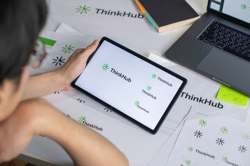 Male Asian graphic designer working in an office studio, using tablet, designing logos and...