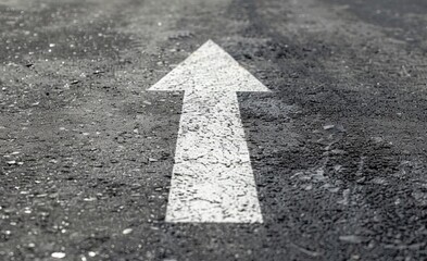 white arrow on asphalt road, close up.