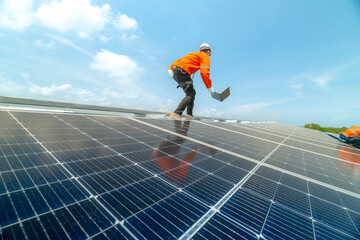 engineer man inspects construction of solar cell panel or photovoltaic cell by electronic device. Industrial Renewable energy of green power. factory worker working on tower roof.
