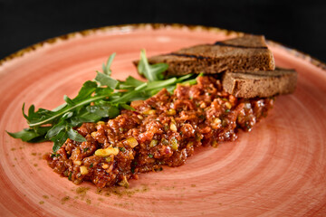 Beef Tartare with Toast and Fresh Greens on a Rustic Plate