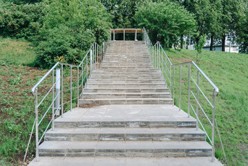 Obraz premium stone staircase with metal railings in city park in summer day, green grass on sides, place for walking and cardio training, no people