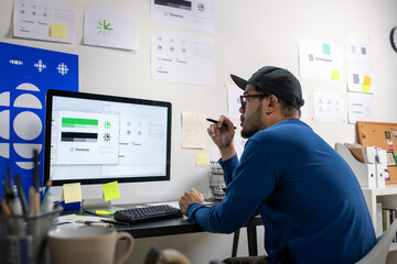 Asian graphic designer working on logo designs, using computers, designing logos, and showcasing the corporate identity and logo design process.