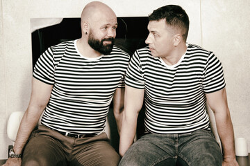 Adult gay couple in a new apartment. Two handsome elderly men relaxing together. Love and romance.