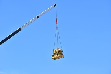 Obraz premium wooden pallets hanging against blue sky background