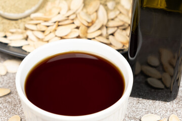 Pumpkin oil among scattered pumpkin seeds.