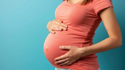 A woman is wearing a black dress and holding her stomach. She is pregnant and wearing a ring on her finger