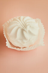 One marshmallow brownie in a white paper tartlet on a pink background vertical shot