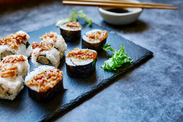 Set of sushi and maki with soy sauce over blue stone background. Take-away food concept