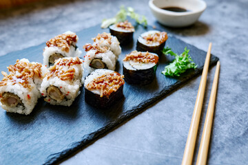 Set of sushi and maki with soy sauce over blue stone background. Take-away food concept