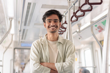 Portrait of young Indian man passenger traveling in the metro. Delhi metro and Public...