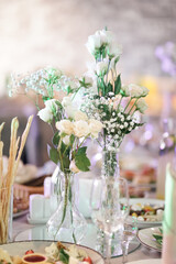Serving the festive table. A bouquet of flowers in a vase on the table.