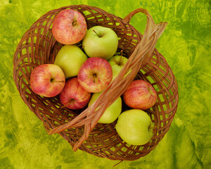 Green and red apples in basket top view