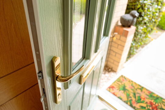 Newly installed, uPVC front door showing the brass fittings. Also in view are the multiple bolts used to secure the door by lifting up the door handle.