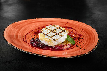 Grilled Camembert Cheese with Berry Sauce on a Rustic Plate