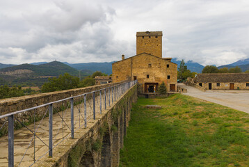 Las murallas del castillo de Ainsa, Aragón, España, se extienden a lo largo de una sólida...