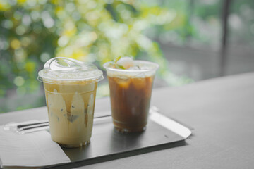 Close up glass of ice black coffee with lychee juice and ice cappucino on raw cement table of a...