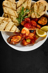Delicious Seafood Saute in Tomato Sauce with Ciabatta Bread and Lemon Garnish