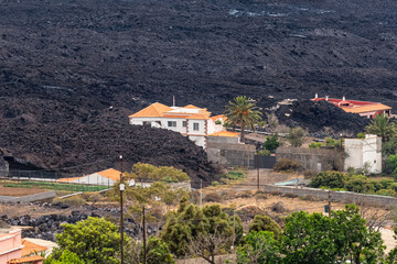 Volcanic lava emitted by the Cumbre Vieja volcano next to the houses on the island of La Palma,...