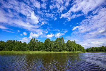 Beautiful summer river at sunny day with clouds reflection in the water