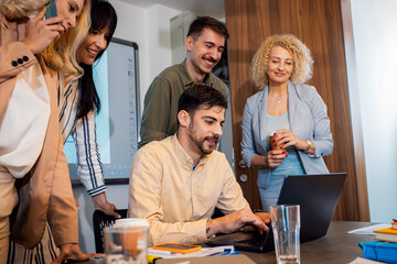 Group of business people sitting in a meeting room discussing a design for a smartphone application.