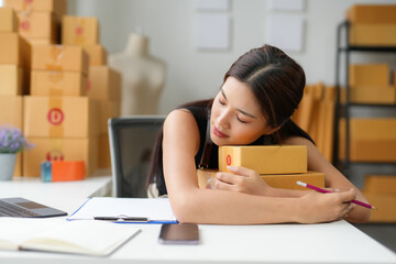 Asian sme business owner sleeping on parcels after packing online orders