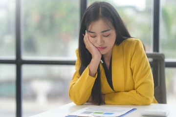 Asian businesswoman feeling tired and stressed while working