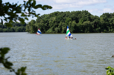 Paddle boarding and sailing on a lake 