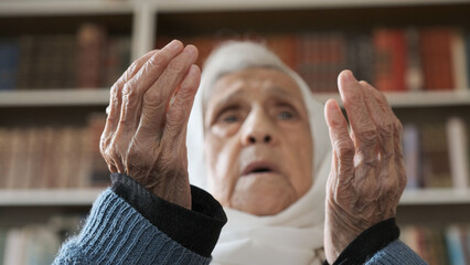 Old muslim woman praying for god to bless her and give her strength