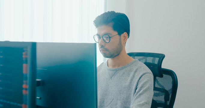 Young adult Asia male freelance eyeglasses typing write prompt AI bot IT app smart program nomad, video game, terminal with coding, user interface, designer, big data center on desktop computer.