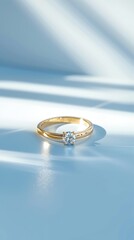A minimalistic diamond engagement ring on a light blue background