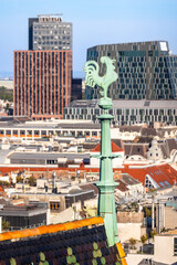 Cockerel weather vane of Stephansdom in Vienna with high-rise towers in background