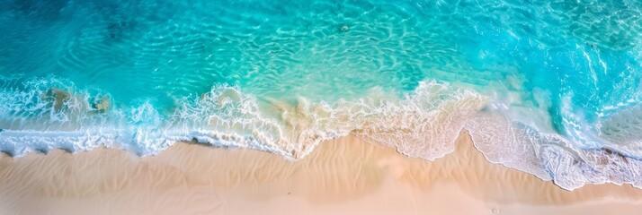A stunning aerial photograph captures the vibrant turquoise water of a tropical beach as it crashes onto a pristine white sandy coastline