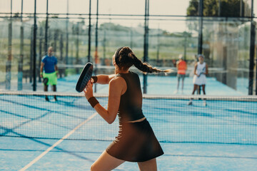 Young female athlete engaged in a padel match on the court