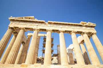 Obraz premium Ancient Parthenon Temple on top of the Acropolis Athens, Greece at sunny day with a blue sky. The landmark of Athens. Parthenon is the temple of for dedication to the goddess Athena.