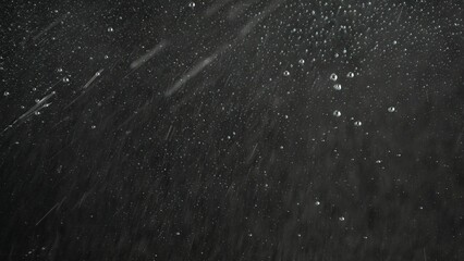Spray foam water on a black glass screen, isolated background with liquid bubbles flowing over the surface, opposing view scene.