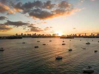 A stunning sunset over the Miami skyline with boats floating on the calm waters of Biscayne Bay