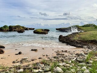 view of a small wild beach with sand and pebbles on a coastline of Guadeloupe in the French West...