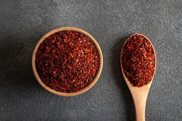Red pepper flakes.Red chili peppers in wooden bowl on black background