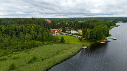 Drone photography of lake, forest and houses near it during summer day