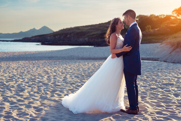 Husband and wife on a beach near the ocean
