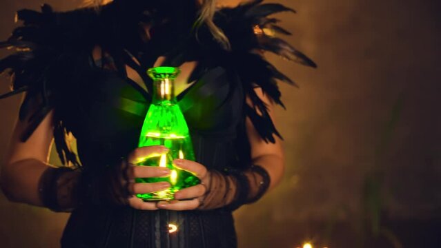 Fantasy woman witch cropped face body part close-up hand holding bottle glowing green liquid potion drink magic light sexy witch girl. Lady Halloween Black dress dark gothic room art b-roll video 4k 