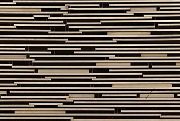 Background, texture of a wall decorated with thin light wooden planks