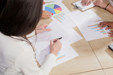 Company employee working together analyzing financial data graphs and planning business strategies.