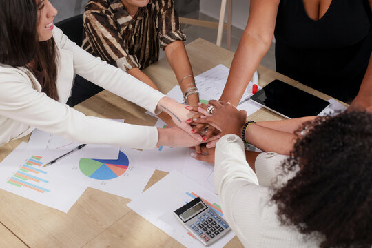 Diverse business team showing unity with hands stacked. Teamwork concept.