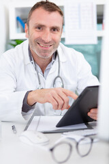 happy doctor working with computer in office