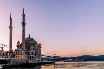 Naklejka premium A long exposure of the Ortakoy Mosque in Istanbul early in the morning with a container ship moving in the background