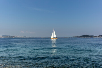 Obraz premium A sailboat in front of Kinaliada in the Princes' Islands near Istanbul