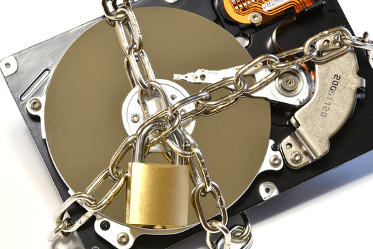 Open hard drive secured with an iron chain and padlock. Cyber ​​security concept. Data of hard drive secured by padlock