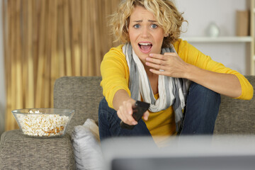 woman scared by tv programme is changing tv channel