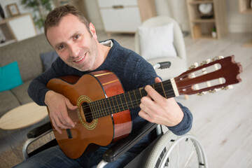 Obraz premium happy handicapped man playing an acoustic guitar